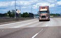 Modern gold big rig semi truck with dry van trailer moving on wi Royalty Free Stock Photo